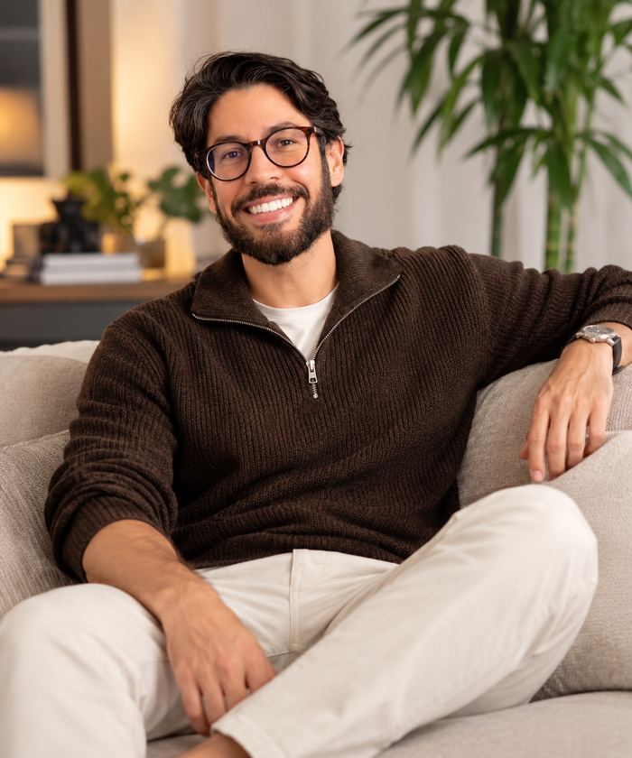 Artur sorrindo, sentado em um sofá